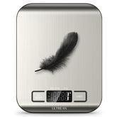 Digital kitchen scale with a feather on top, displaying weight measurement.