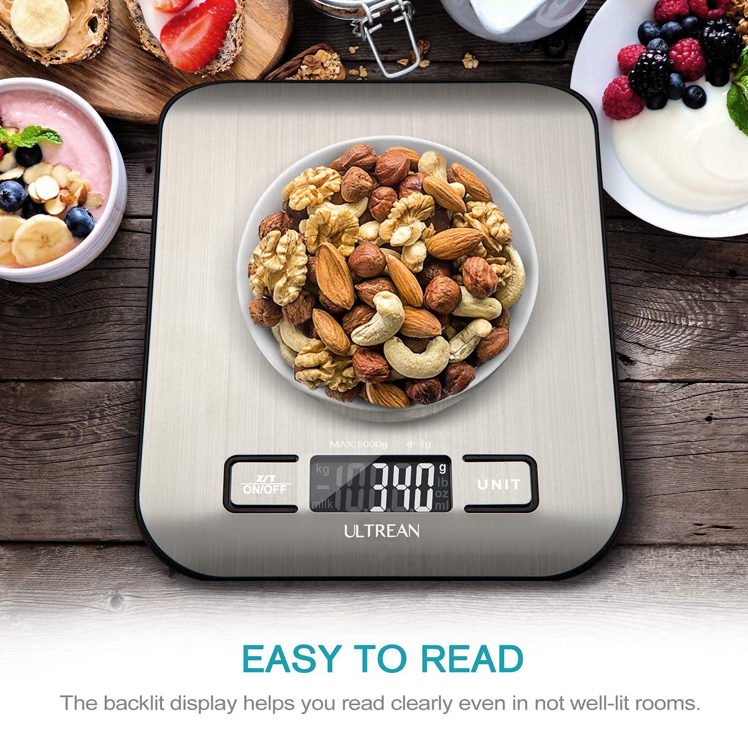 Digital kitchen scale with a bowl of mixed nuts on a wooden surface.